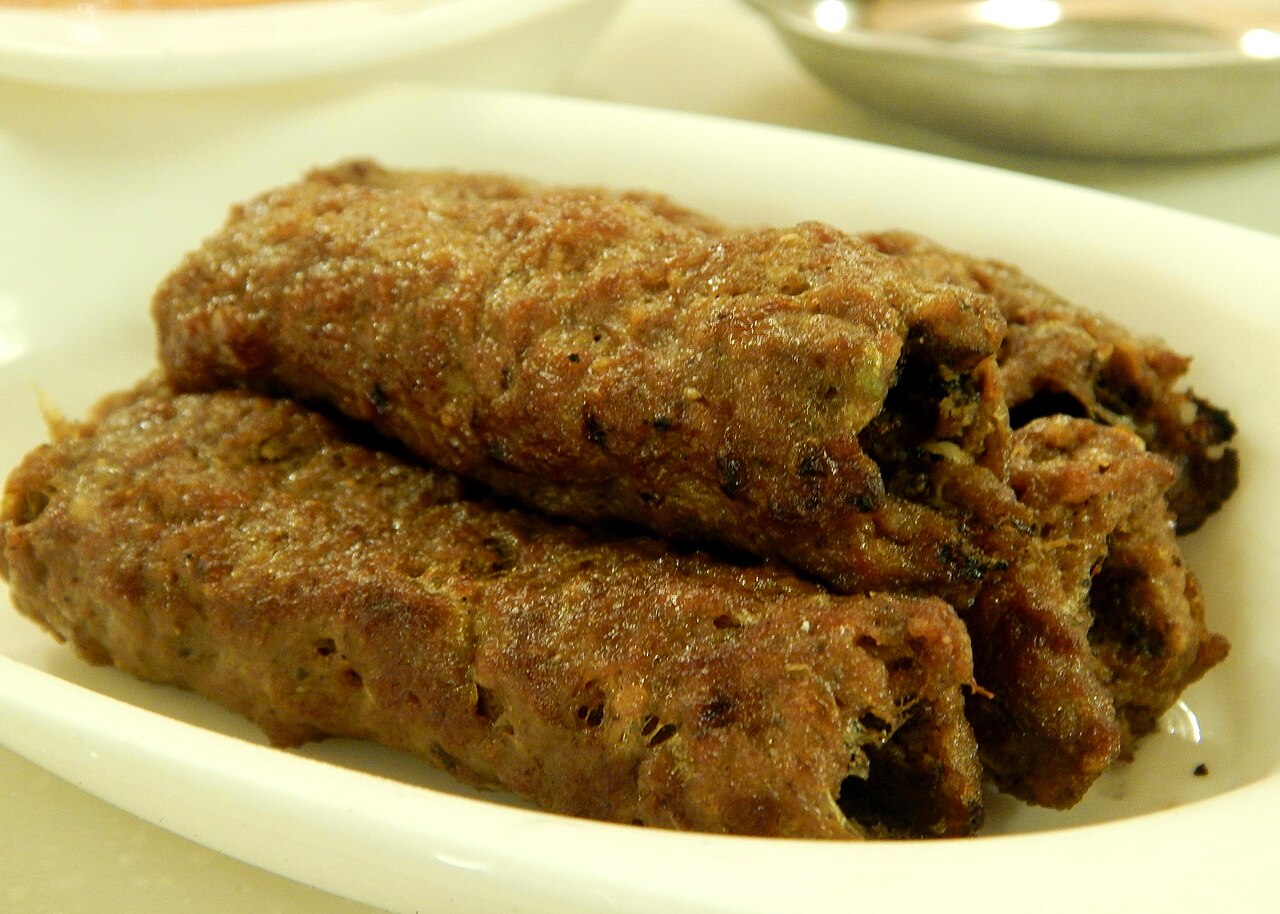 Seekh kebab skewers served with salad and lemon