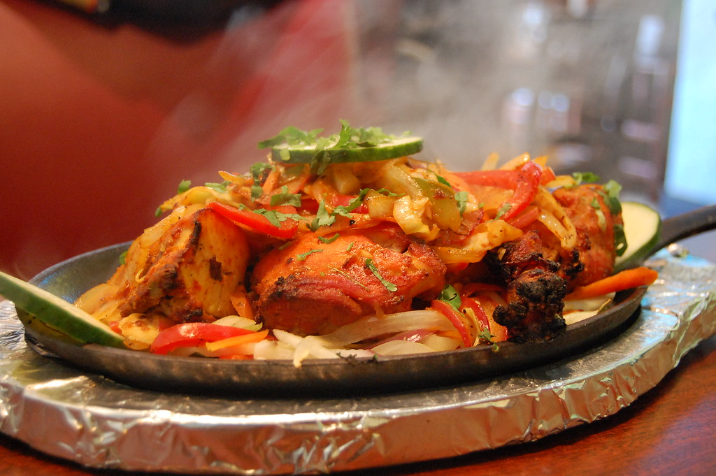 Charcoal-grilled tandoori chicken pieces on a platter