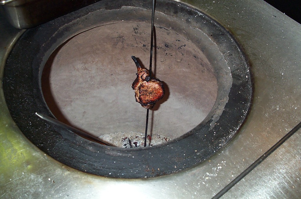 Traditional clay tandoor oven glowing with charcoal